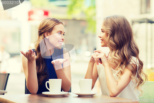 Image of young women drinking coffee and talking at cafe