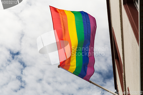 Image of close up of rainbow gay pride flag waving on building