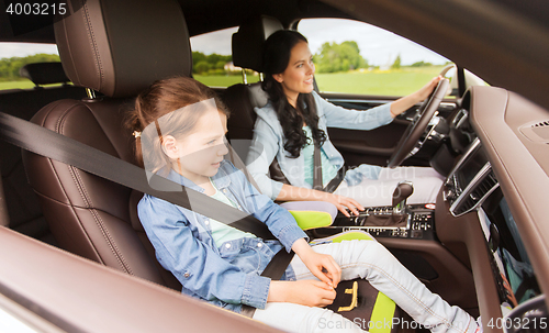 Image of happy woman with little child driving in car