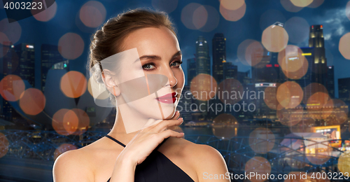 Image of beautiful woman in black over night singapore city