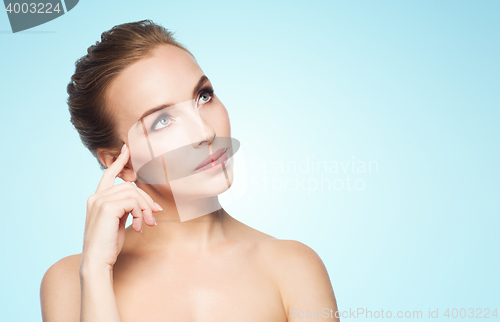 Image of beautiful young woman touching her face