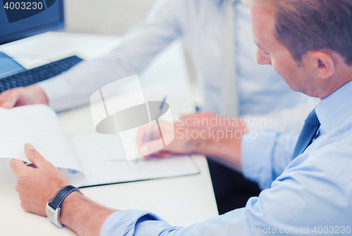 Image of businessmen with notebook on meeting
