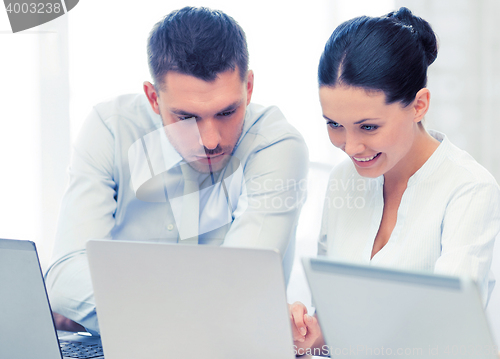 Image of group of people working with laptops in office