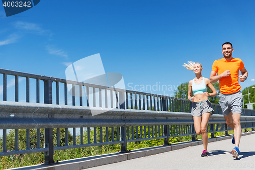 Image of smiling couple running at summer seaside