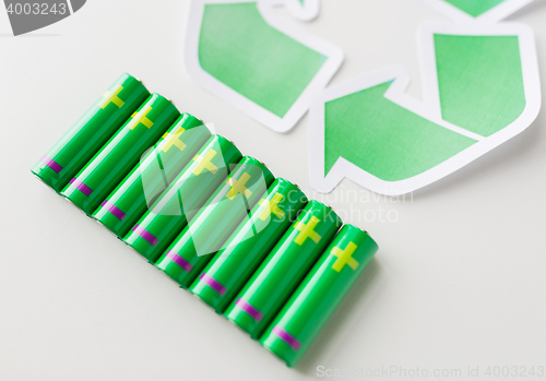 Image of close up of batteries and green recycling symbol