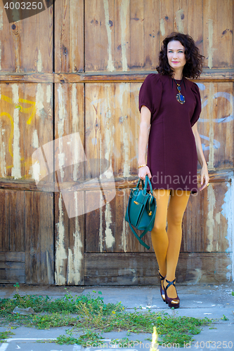 Image of beautiful middle-aged brunette in burgundy dress