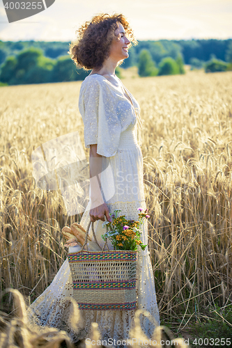 Image of Woman Outdoors with wicker bag with natural meal 