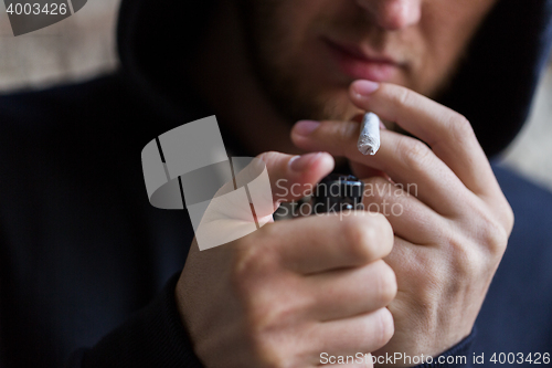 Image of close up of addict lighting up marijuana joint