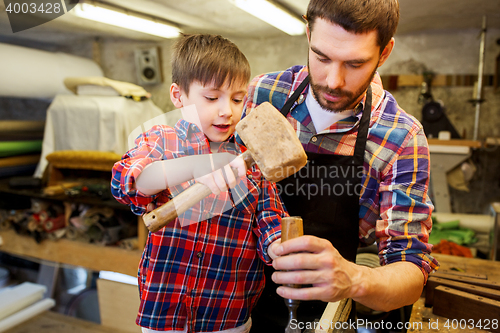 Image of father and son with chisel working at workshop