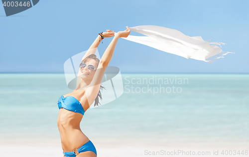 Image of happy woman in bikini and sunglasses on a beach