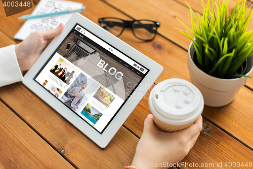 Image of close up of woman with tablet pc on wooden table