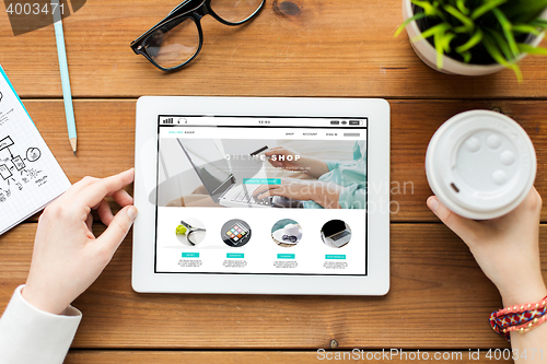 Image of close up of woman with tablet pc on wooden table