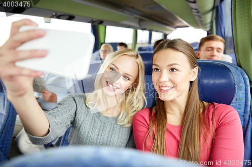 Image of women taking selfie by smartphone in travel bus