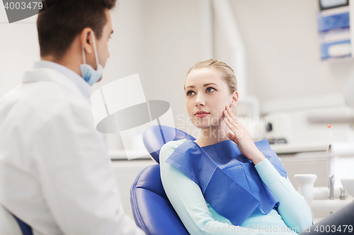 Image of male dentist with woman patient at clinic