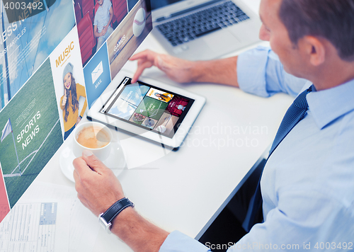 Image of businessman with tablet pc and coffee in office