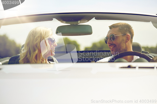 Image of happy man and woman driving in cabriolet car