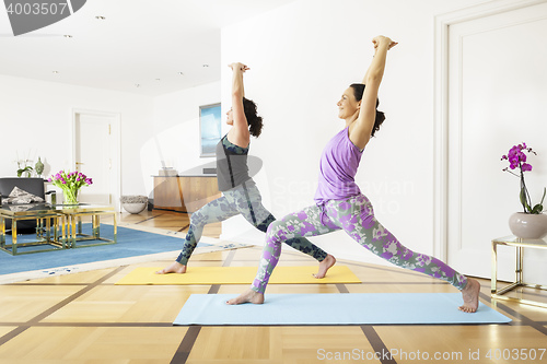 Image of two women doing yoga at home