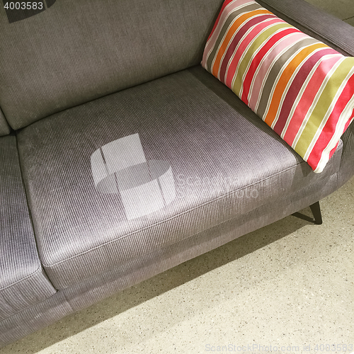 Image of Gray sofa with colorful striped cushion