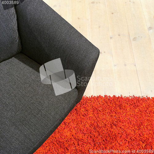 Image of Gray textile armchair on red carpet