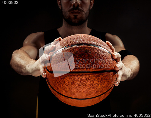 Image of Silhouette view of a basketball player holding basket ball on black background