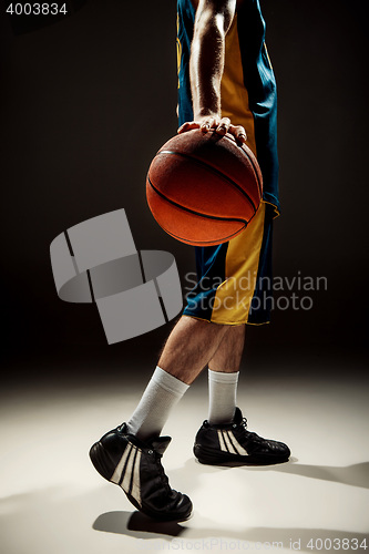 Image of Silhouette view of a basketball player holding basket ball on black background