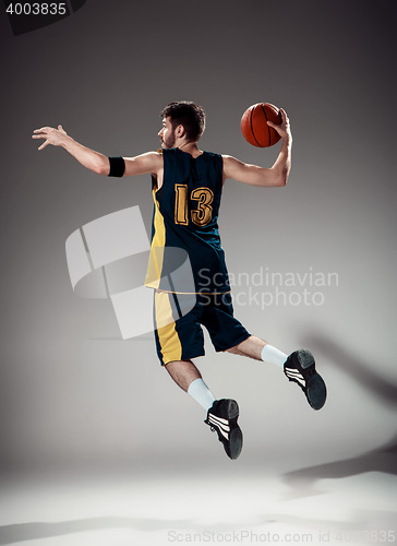 Image of Full length portrait of a basketball player with ball