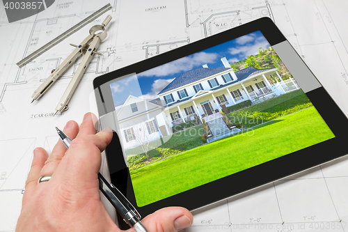 Image of Hand of Architect on Computer Tablet Showing Home Photo Over Hou