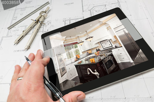 Image of Hand of Architect on Computer Tablet Showing Kitchen Photo Over 