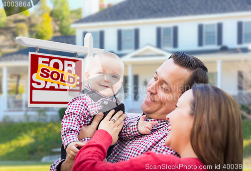 Image of Young Family In Front of For Sale Sign and House
