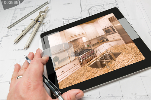 Image of Hand of Architect on Computer Tablet Showing Kitchen Photo Over 