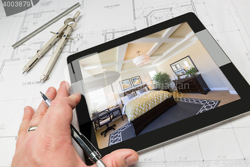 Image of Hand of Architect on Computer Tablet Showing Bedroom Over House 
