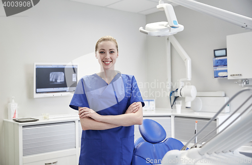 Image of happy young female dentist at dental clinic office