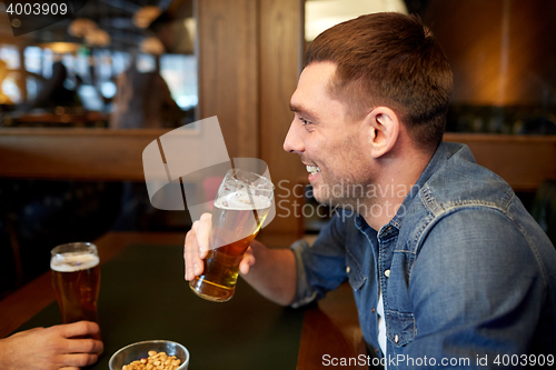 Image of happy man drinking draft beer at bar or pub