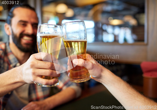 Image of happy male friends drinking beer at bar or pub