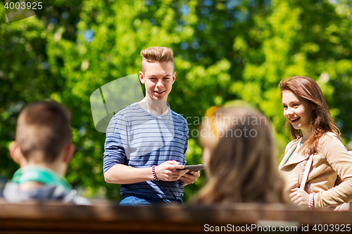 Image of group of teenage students with tablet pc outoors