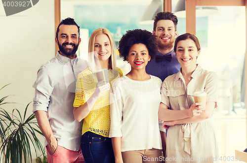 Image of happy smiling creative team with coffee in office