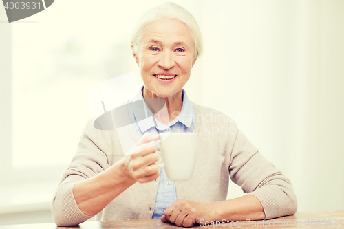 Image of happy senior woman with cup of tea or coffee