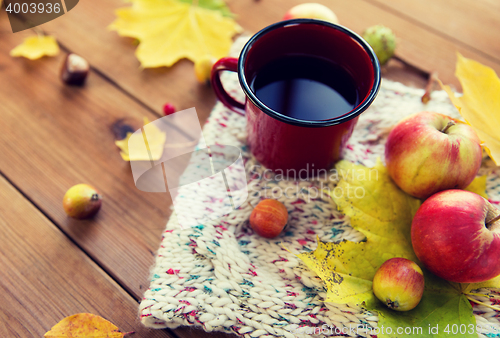 Image of close up of tea cup on table with autumn leaves