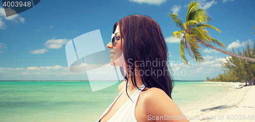 Image of smiling young woman with sunglasses on beach