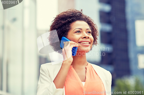 Image of happy african businesswoman calling on smartphone