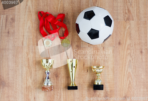 Image of football or soccer ball, golden cups and medals