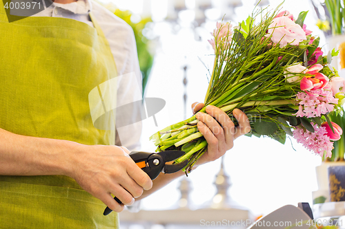 Image of close up of florist man with flowers and pruner