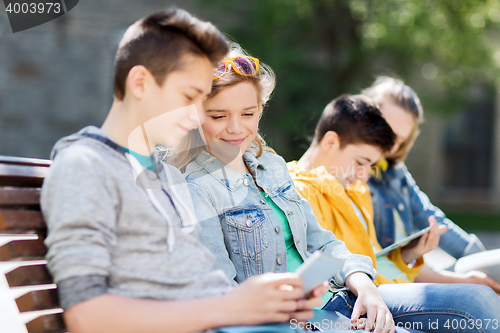 Image of happy teenage friends with tablet pc outdoors