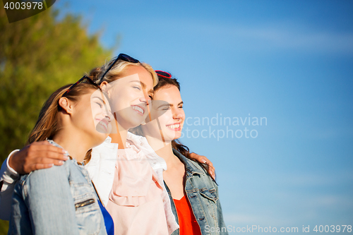 Image of happy women or teenage girls hugging outdoors
