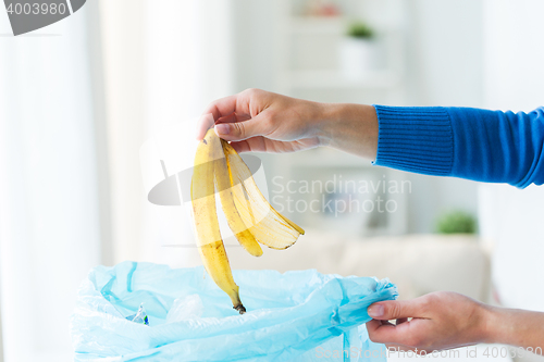 Image of close up of hand putting food waste to rubbish bag