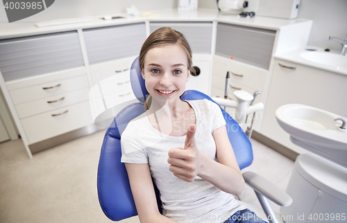 Image of happy patient girl showing thumbs up at clinic