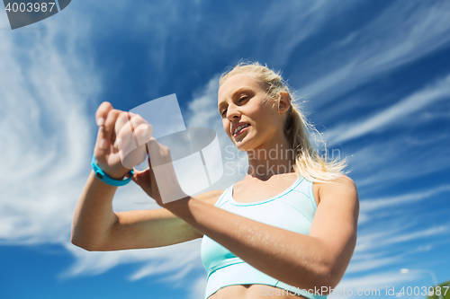 Image of happy woman with heart rate watch and earphones