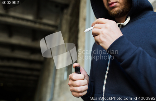 Image of close up of addict hands with marijuana joint