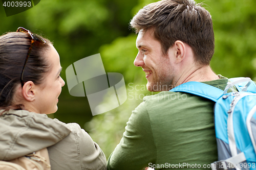 Image of smiling couple with backpacks in nature