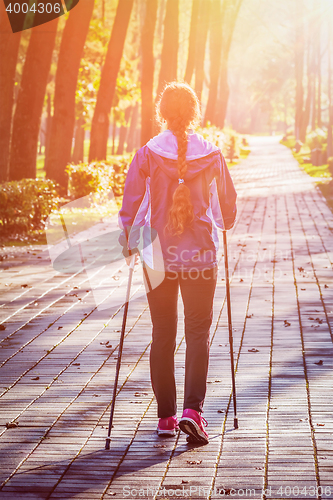 Image of Woman nordic walking outdoors